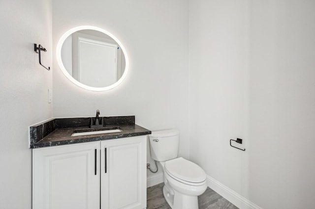 bathroom with hardwood / wood-style floors, vanity, and toilet