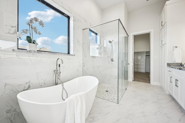 bathroom featuring vanity and independent shower and bath