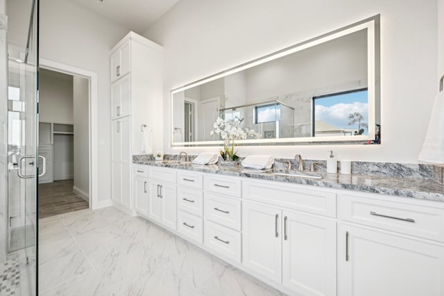 bathroom with vanity and a shower with shower door