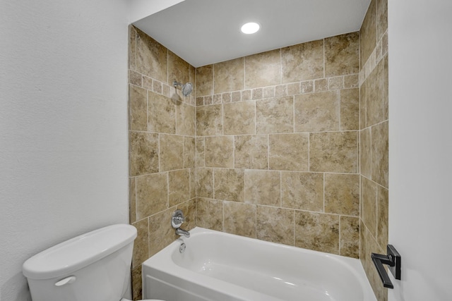 bathroom with toilet and tiled shower / bath combo