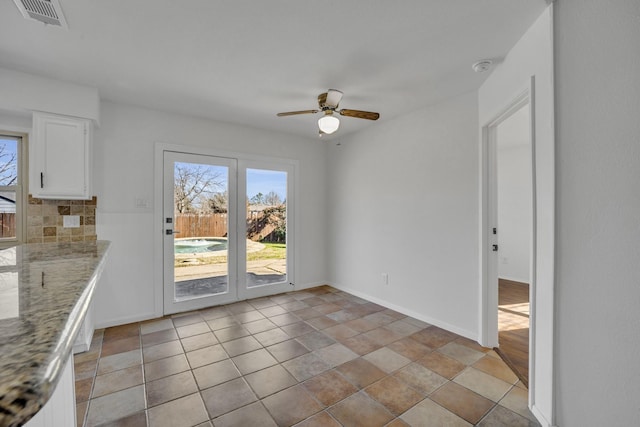 unfurnished dining area featuring ceiling fan and light tile patterned floors