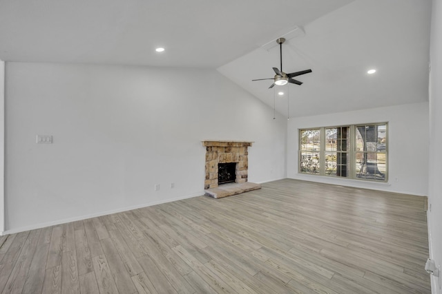 unfurnished living room featuring ceiling fan, high vaulted ceiling, a fireplace, and light hardwood / wood-style flooring