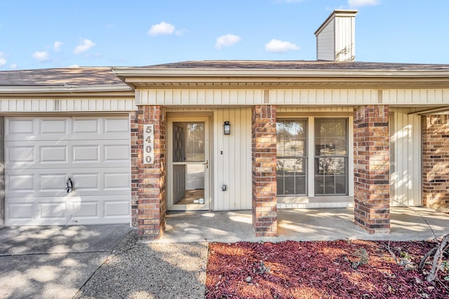 doorway to property with a porch and a garage