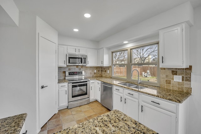 5400 Gregory Dr, Flower Mound, TX 75028 - kitchen featuring stainless steel appliances, a sink, white cabinets, tasteful backsplash, and recessed lighting