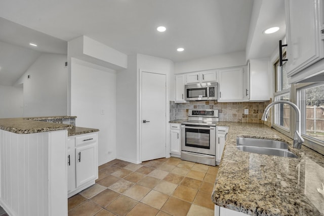 5400 Gregory Dr, Flower Mound, TX 75028 - kitchen featuring appliances with stainless steel finishes, a sink, stone countertops, decorative backsplash, and white cabinetry