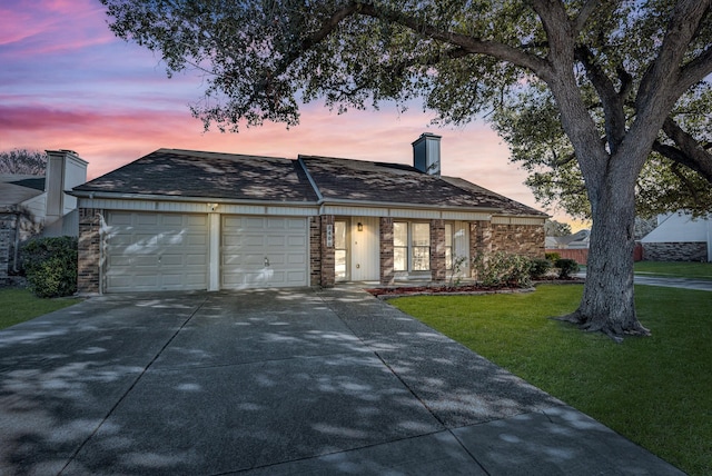 ranch-style home with a garage and a lawn