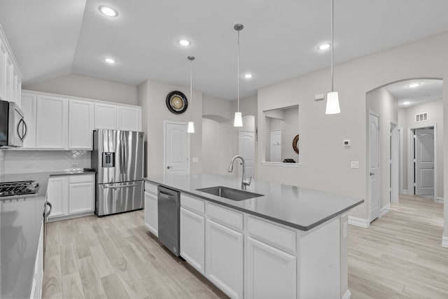 kitchen featuring appliances with stainless steel finishes, sink, pendant lighting, a center island with sink, and white cabinets