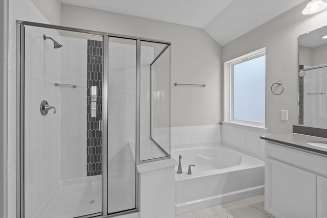 bathroom featuring vanity, shower with separate bathtub, and vaulted ceiling