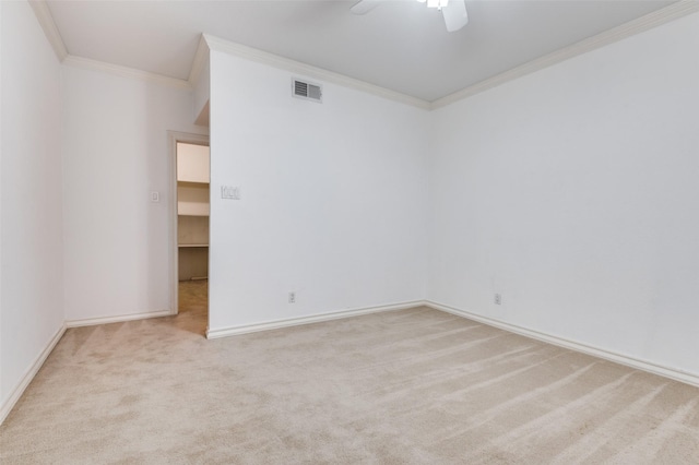 carpeted empty room with ceiling fan and crown molding