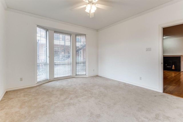 unfurnished room featuring light carpet, ceiling fan, and ornamental molding