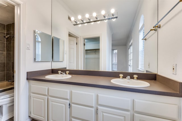 full bathroom with vanity, toilet, crown molding, and tiled shower / bath combo