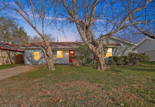 ranch-style home with driveway, a garage, and a front lawn