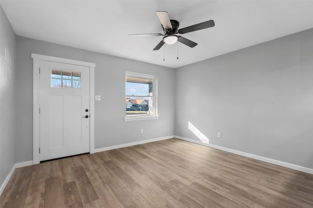 foyer entrance featuring ceiling fan, baseboards, and wood finished floors