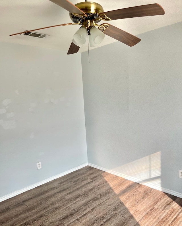 empty room with ceiling fan and dark hardwood / wood-style flooring