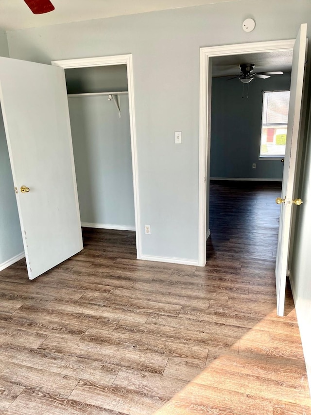 unfurnished bedroom featuring wood-type flooring, a closet, and ceiling fan