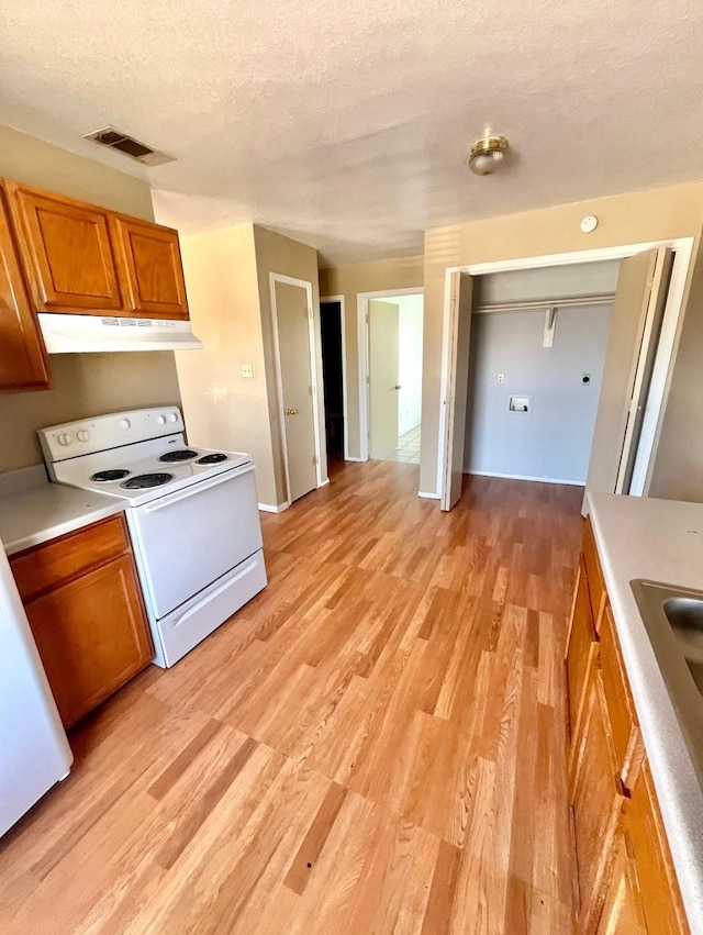 kitchen with white range with electric cooktop, light hardwood / wood-style floors, and a textured ceiling