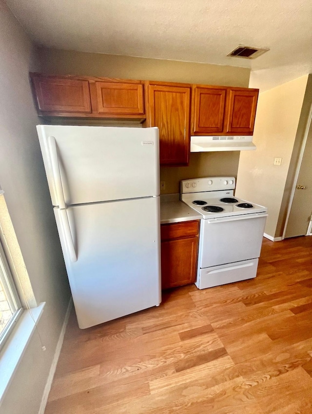 kitchen featuring light hardwood / wood-style floors and white appliances