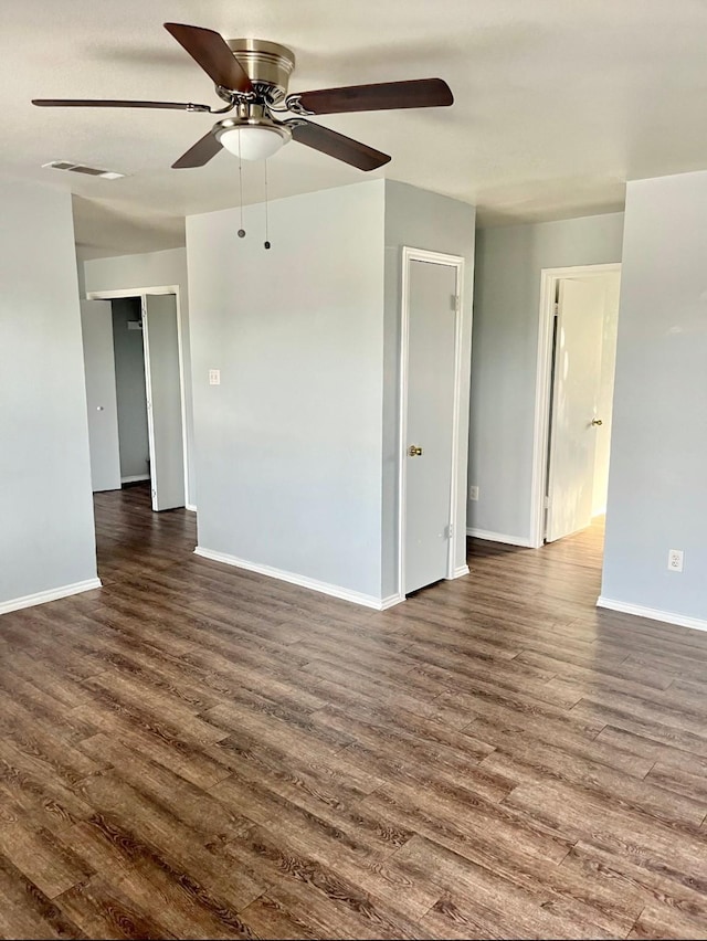 empty room featuring dark hardwood / wood-style flooring and ceiling fan