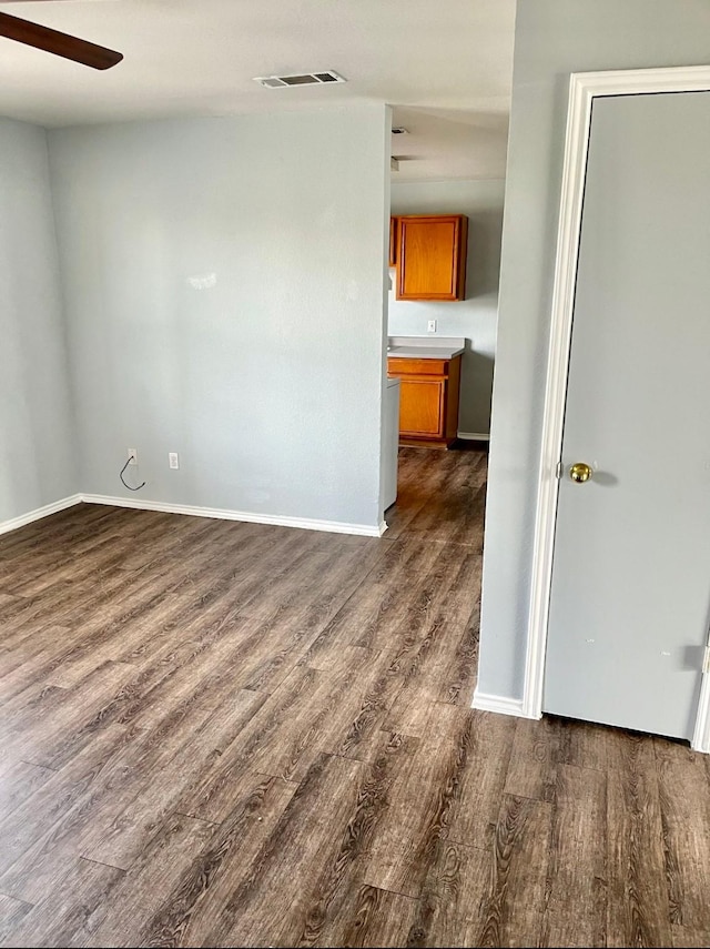 unfurnished room featuring ceiling fan and dark hardwood / wood-style flooring