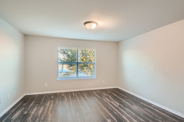 unfurnished room with dark hardwood / wood-style flooring