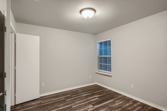 unfurnished room with dark hardwood / wood-style floors and a textured ceiling