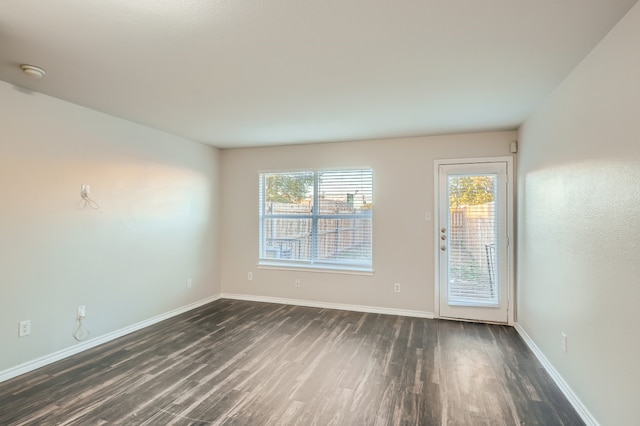 empty room with dark hardwood / wood-style flooring