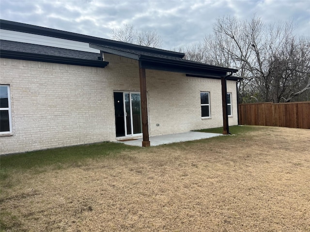 back of property featuring a lawn and a patio