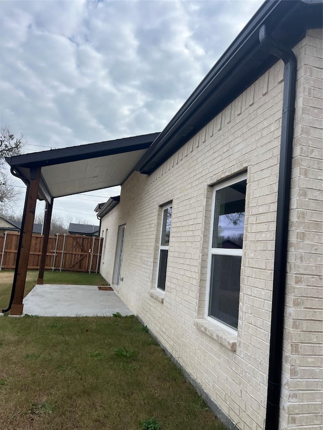 view of property exterior with a lawn and a patio area