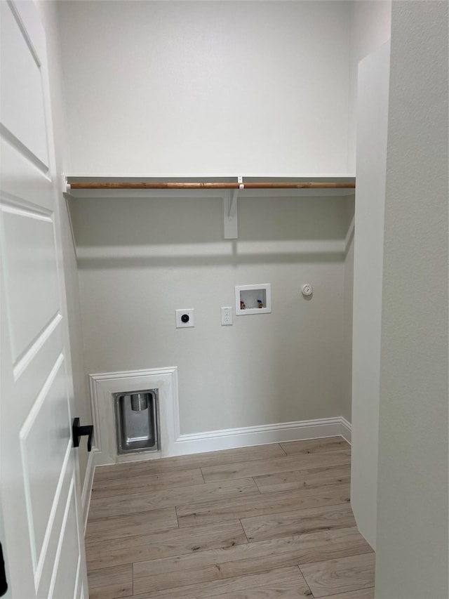 laundry area featuring electric dryer hookup, gas dryer hookup, light hardwood / wood-style flooring, and washer hookup