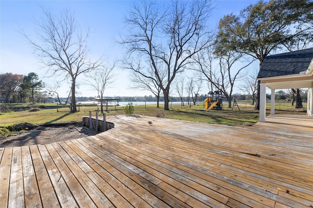 wooden terrace with a playground and a yard