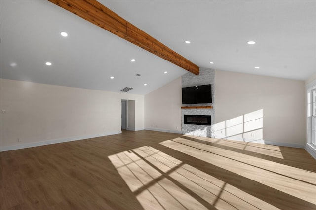 unfurnished living room with hardwood / wood-style flooring, lofted ceiling with beams, and a fireplace