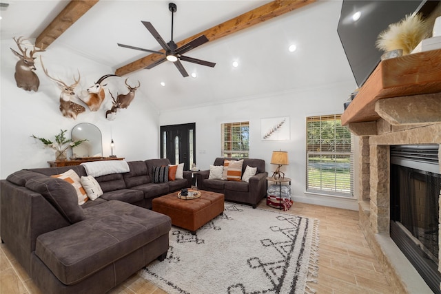 living room with vaulted ceiling with beams, ceiling fan, and a fireplace