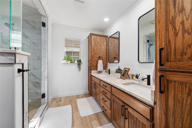 bathroom with ornamental molding, vanity, wood-type flooring, and walk in shower