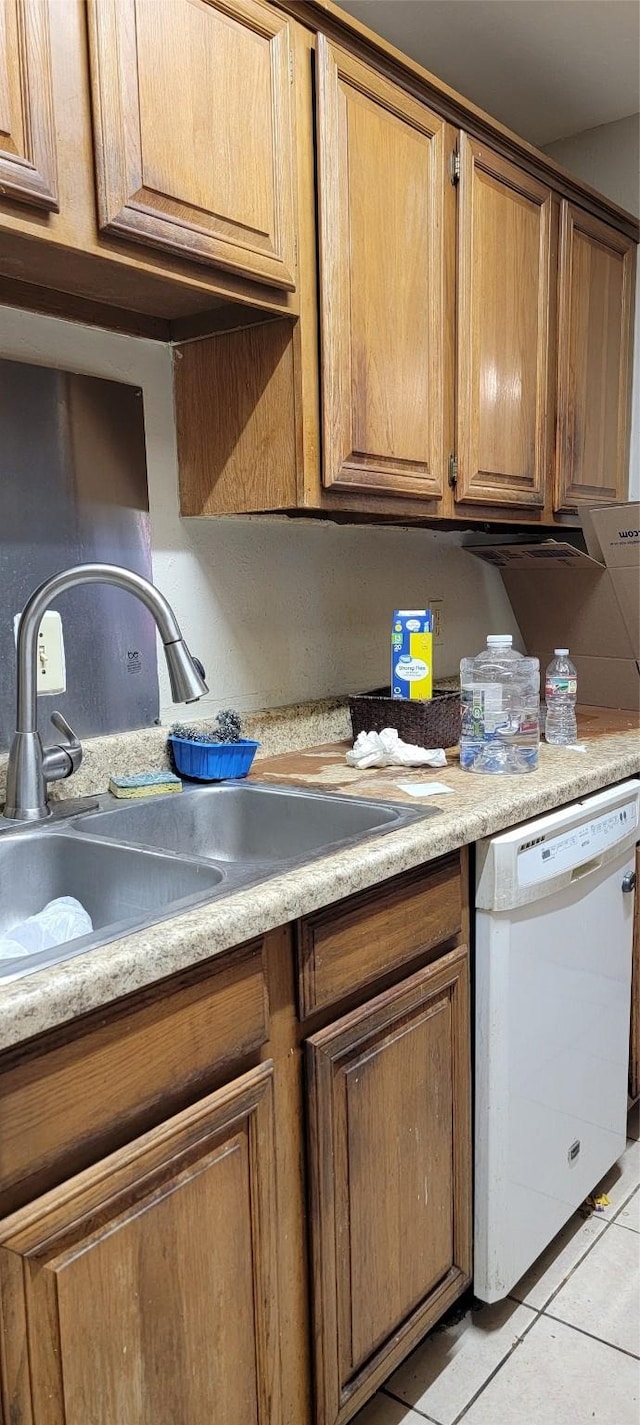 kitchen with dishwasher, light tile patterned floors, and sink