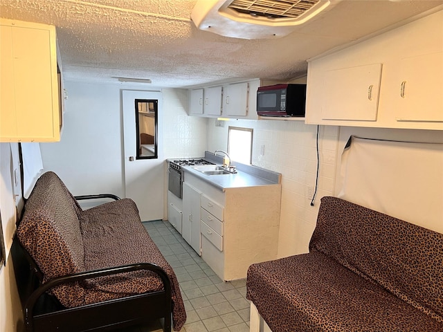 kitchen featuring sink, a textured ceiling, and range with gas stovetop