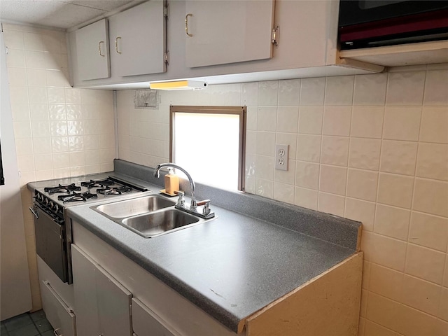 kitchen with tile walls, backsplash, sink, and range with gas stovetop