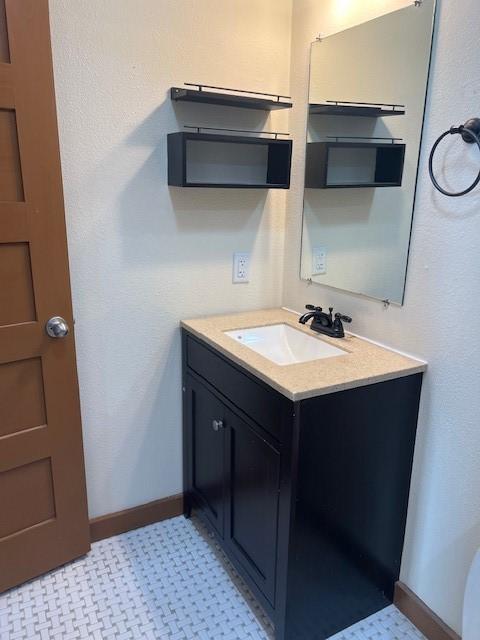 bathroom with baseboards and vanity