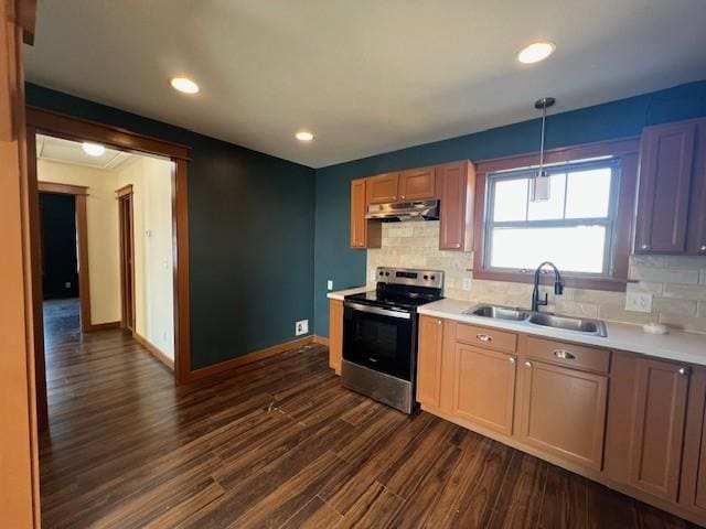 kitchen featuring stainless steel electric range, backsplash, dark wood-type flooring, sink, and hanging light fixtures