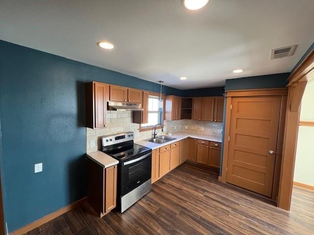 kitchen featuring electric range, sink, dark hardwood / wood-style floors, backsplash, and pendant lighting