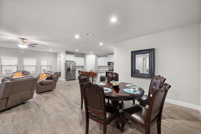 dining area featuring ceiling fan, light hardwood / wood-style floors, and sink