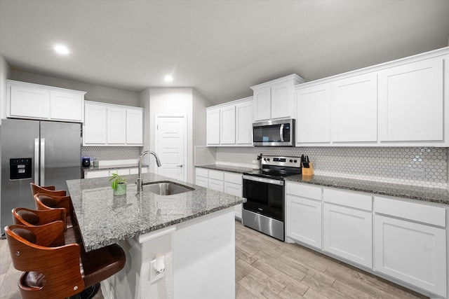 kitchen featuring white cabinets, decorative backsplash, sink, and appliances with stainless steel finishes