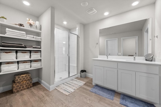 bathroom featuring vanity, wood-type flooring, and a shower with door