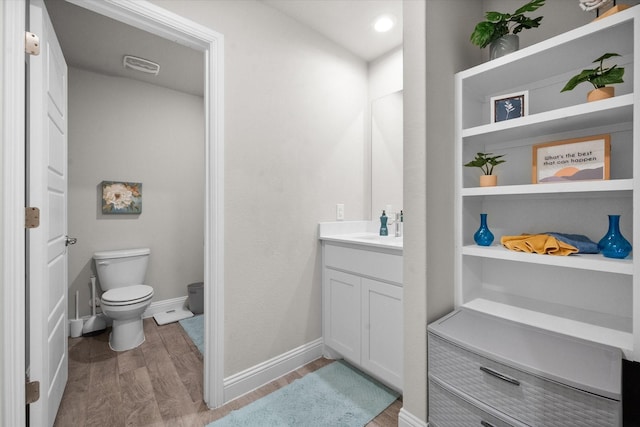 bathroom featuring vanity, wood-type flooring, and toilet