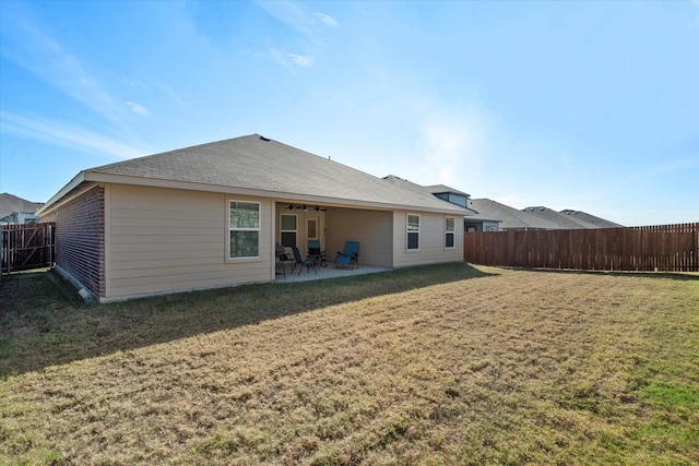 rear view of house featuring a yard and a patio