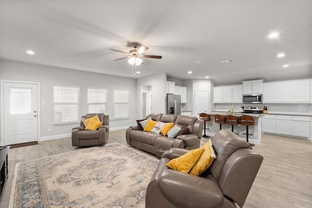 living room featuring ceiling fan and light wood-type flooring