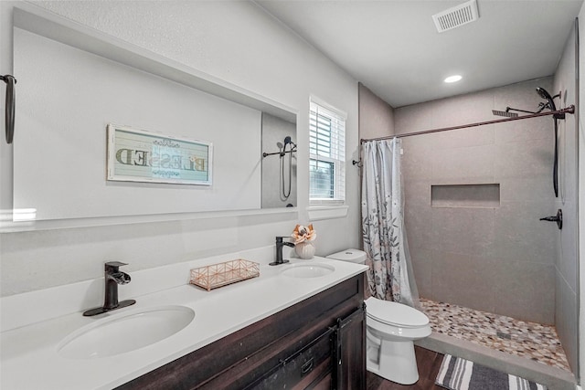 bathroom with toilet, a shower with shower curtain, hardwood / wood-style floors, and vanity