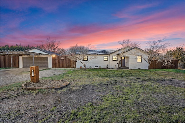 ranch-style home with a garage and a yard