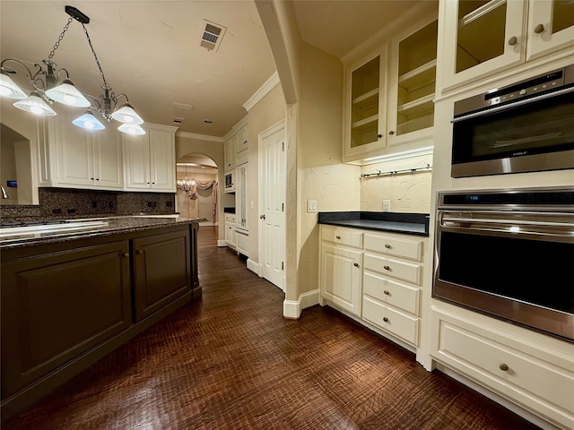 kitchen with decorative light fixtures, appliances with stainless steel finishes, a notable chandelier, and ornamental molding