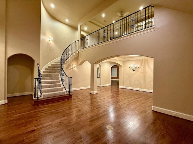 interior space with a high ceiling, dark hardwood / wood-style floors, and a chandelier