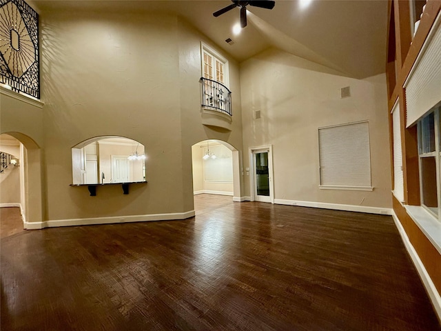 unfurnished living room with ceiling fan, dark hardwood / wood-style flooring, and high vaulted ceiling